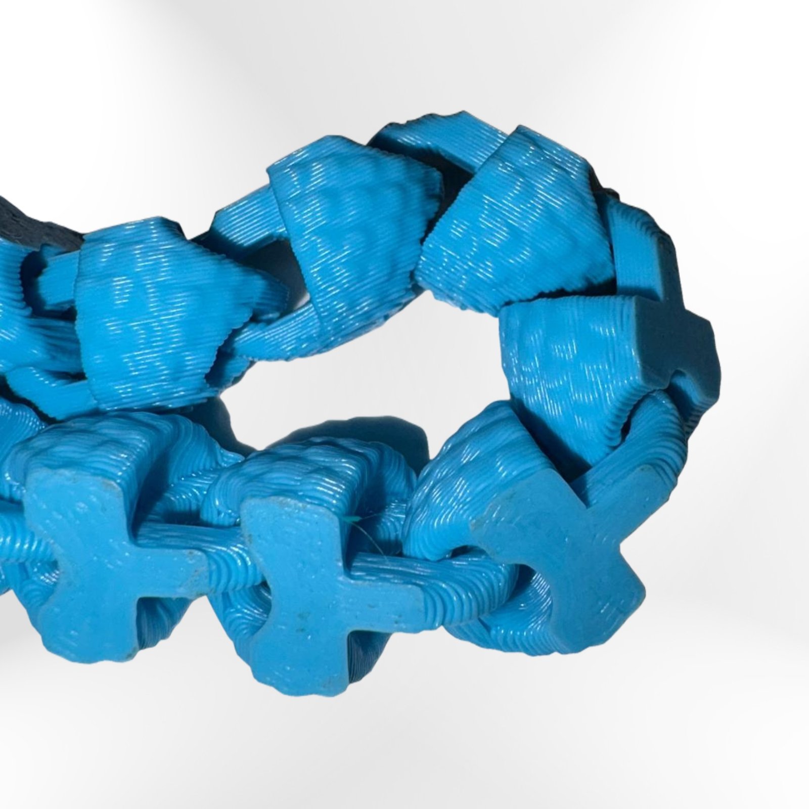 Scaled Fidget Snake: Blue 3D-printed fidget toy, interlocking cross-shaped segments for stress and anxiety relief. Scaled Fidget Snake: Blue 3D-printed fidget toy, interlocking cross-shaped segments for stress and anxiety relief.