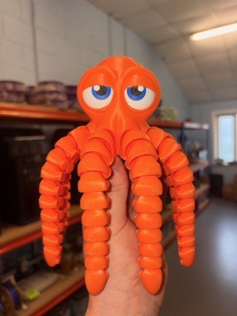 4601600c 3a30 4be8 B07f B59f115f35ae Orange Octopus toy with big blue eyes and segmented, flexible tentacles.