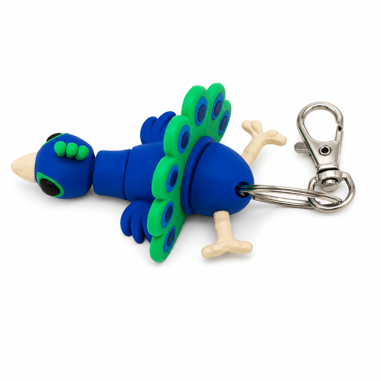 Blue and green clay peacock keyring with a silver clasp, lying on a white background. Blue and green clay peacock keyring with a silver clasp, lying on a white background.